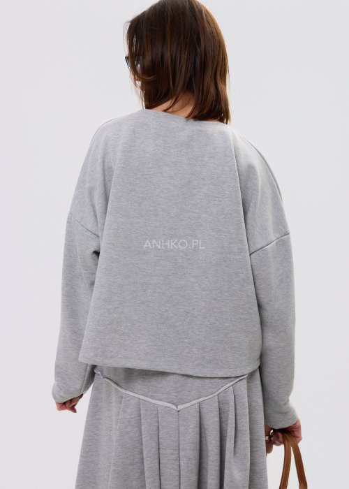 Szara damska bluza oversize z długim rękawem i zaokrąglonym dekoltem z dekoracyjną wstawką z denimu na przodzie.