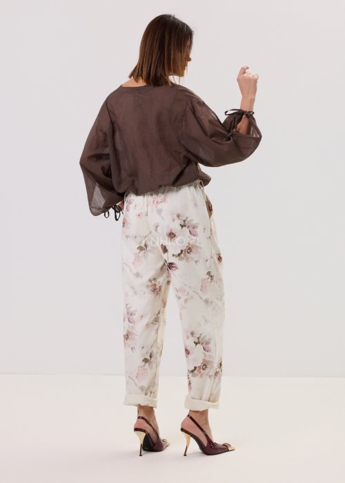 Brązowa, lekka bluzka damska z półprzezroczystej tkaniny, z dekoltem w serek, zapinana na guzik, z długimi rękawami zakończonymi wiązaniem.