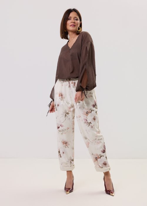 Brązowa, lekka bluzka damska z półprzezroczystej tkaniny, z dekoltem w serek, zapinana na guzik, z długimi rękawami zakończonymi wiązaniem.