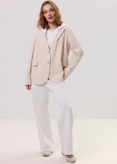 Beżowa marynarka damska z kapturem, zapinana na guziki, o luźnym kroju z kieszeniami, prezentowana w minimalistycznej stylizacji.