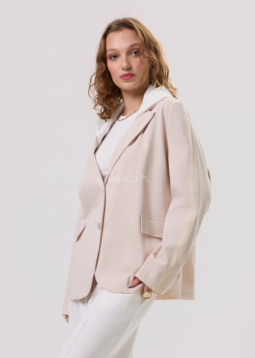 Beżowa marynarka damska z kapturem, zapinana na guziki, o luźnym kroju z kieszeniami, prezentowana w minimalistycznej stylizacji.
