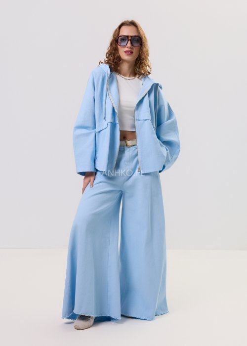 Niebieska kurtka damska z kapturem zapinana na zamek, o luźnym kroju z długim rękawem, prezentowana w stylizacji casual.