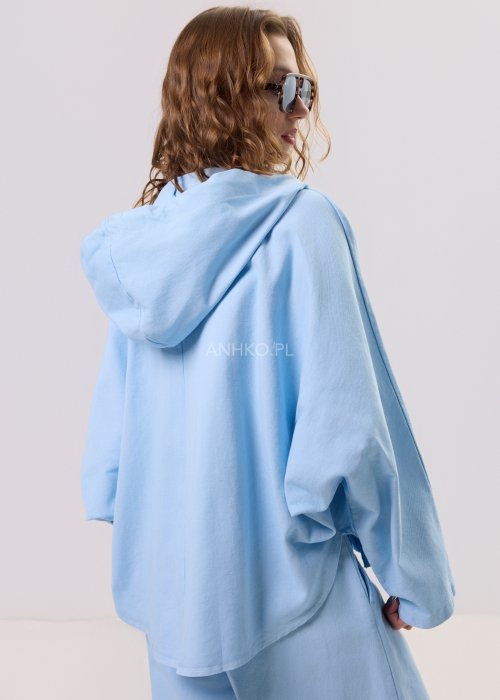 Niebieska kurtka damska z kapturem zapinana na zamek, o luźnym kroju z długim rękawem, prezentowana w stylizacji casual.