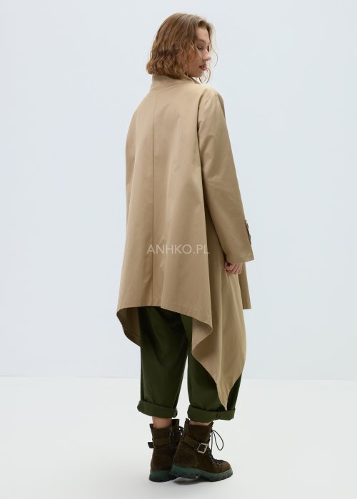 Beżowy płaszcz damski o luźnym, asymetrycznym kroju z wysokim kołnierzem. Model zapinany na zamek, z dekoracyjnymi guzikami przy kołnierzu i mankietach.