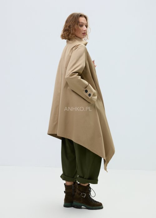 Beżowy płaszcz damski o luźnym, asymetrycznym kroju z wysokim kołnierzem. Model zapinany na zamek, z dekoracyjnymi guzikami przy kołnierzu i mankietach.