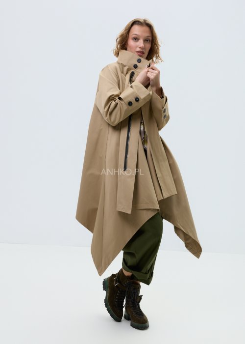 Beżowy płaszcz damski o luźnym, asymetrycznym kroju z wysokim kołnierzem. Model zapinany na zamek, z dekoracyjnymi guzikami przy kołnierzu i mankietach.