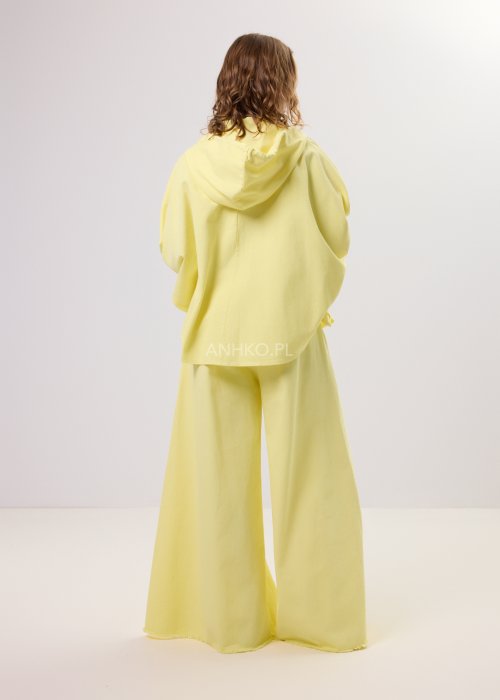 Żółta kurtka damska z kapturem zapinana na zamek, o luźnym kroju z szerokimi rękawami, w lekkim stylu casual.