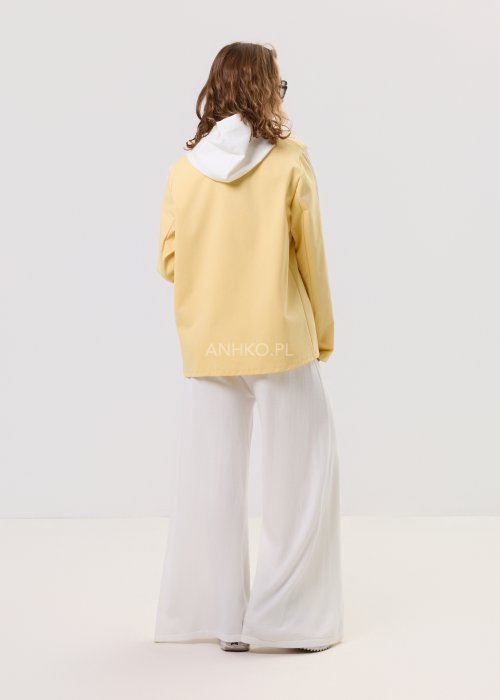 Żółta marynarka damska z kontrastowym kapturem i jasnymi lampasami na rękawach, zapinana na guziki, o luźnym kroju.