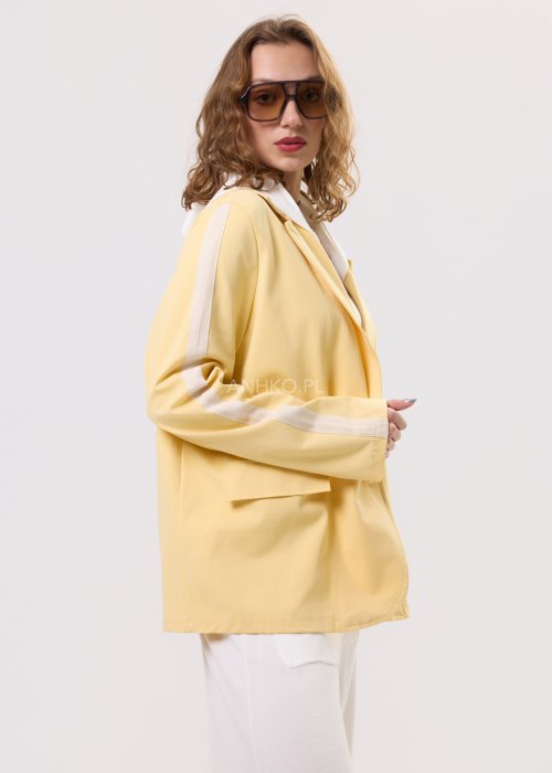 Żółta marynarka damska z kontrastowym kapturem i jasnymi lampasami na rękawach, zapinana na guziki, o luźnym kroju.