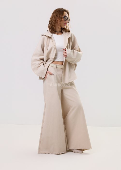 Beżowa kurtka damska z kapturem zapinana na zamek, o luźnym kroju z szerokimi rękawami i kieszeniami, w stylu casual.