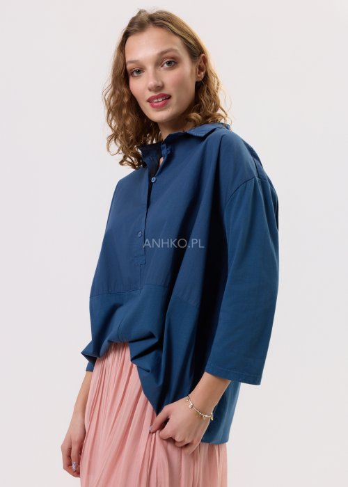 Granatowa koszula oversize z kołnierzykiem i zapięciem na guziki, o luźnym, swobodnym kroju z rękawem 3/4. Stylizacja z plisowaną spódnicą w delikatnym różowym kolorze w kobiecym, miejskim stylu.