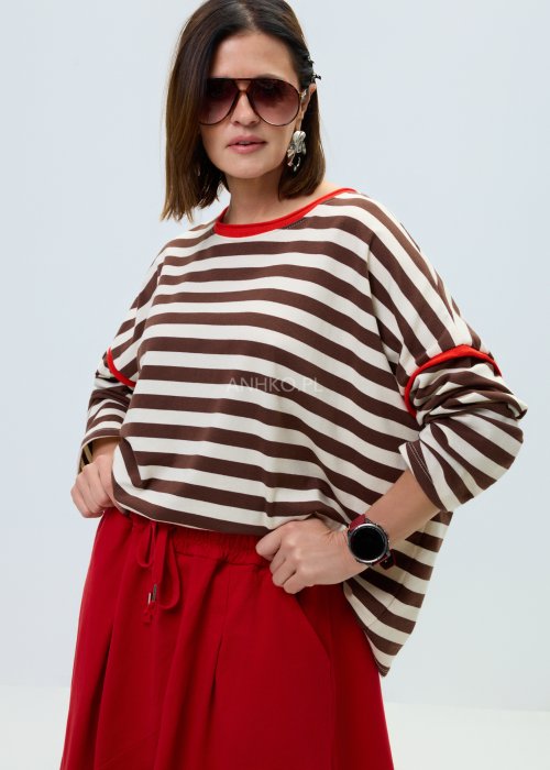 Bluzka damska w brązowo-beżowe paski o luźnym kroju. Model z długim rękawem oraz kontrastowym wykończeniem przy dekolcie i rękawach w kolorze czerwonym.