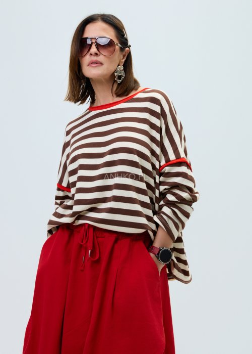 Bluzka damska w brązowo-beżowe paski o luźnym kroju. Model z długim rękawem oraz kontrastowym wykończeniem przy dekolcie i rękawach w kolorze czerwonym.