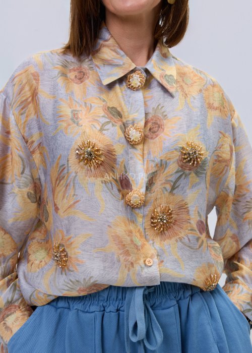 Koszula damska w pastelowym, kwiatowym wzorze z ozdobnymi aplikacjami i biżuteryjnymi guzikami, z klasycznym kołnierzykiem.