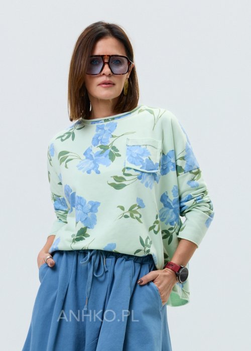 Miętowa bluza damska w niebieskie kwiaty z długim rękawem i ozdobną kieszonką na piersi.