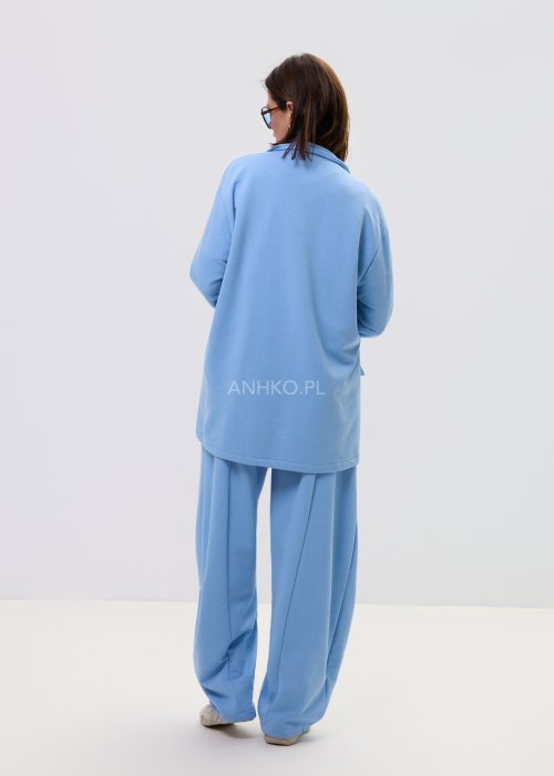 Niebieska damska marynarka oversize zapinana na guziki z kontrastowymi paskami na rękawach i kieszeniach.