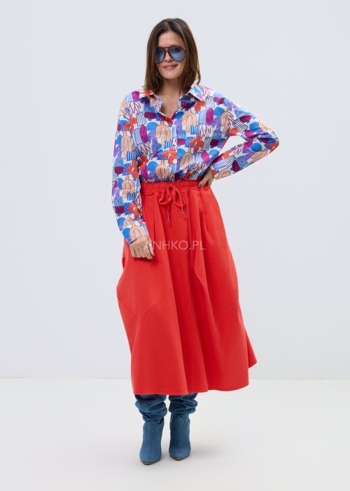Kolorowa damska koszula z długim rękawem i geometryczno-roślinnym wzorem, stylizowana z jasnymi spodniami lub czerwonymi spodniami z wysokim stanem