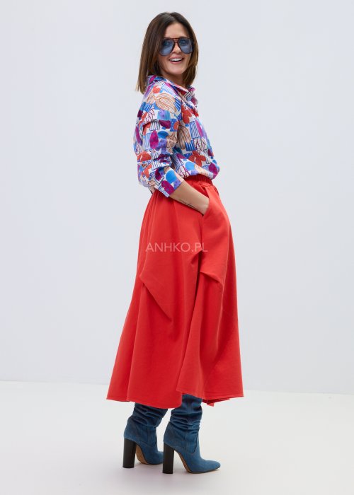 Kolorowa damska koszula z długim rękawem i geometryczno-roślinnym wzorem, stylizowana z jasnymi spodniami lub czerwonymi spodniami z wysokim stanem