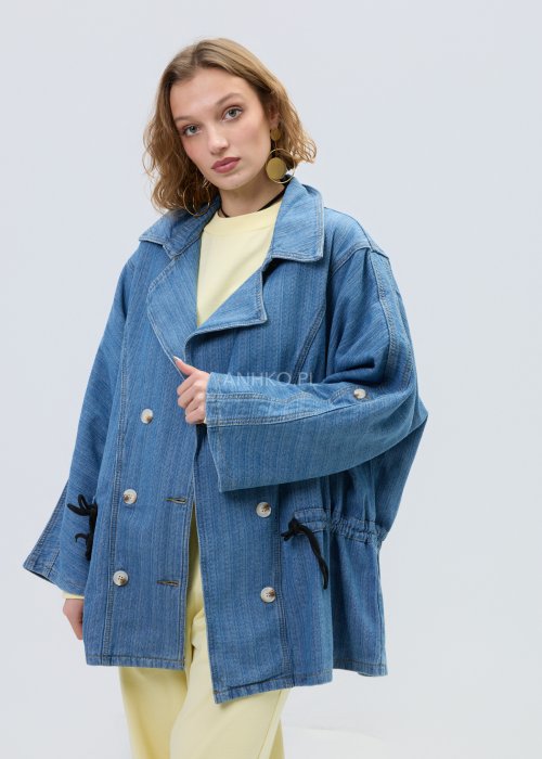 Niebieska kurtka jeansowa oversize z szerokim kołnierzem i zapięciem na guziki, z regulacją w talii na troczki. Stylizacja z jasnym topem i spodniami w nowoczesnym, miejskim stylu.