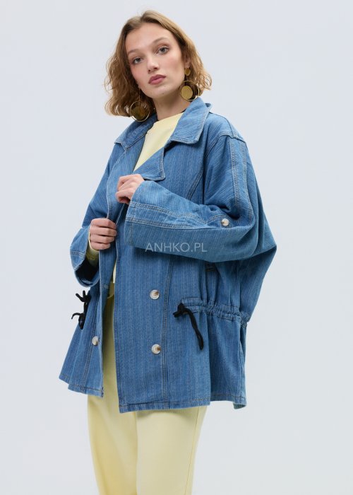 Niebieska kurtka jeansowa oversize z szerokim kołnierzem i zapięciem na guziki, z regulacją w talii na troczki. Stylizacja z jasnym topem i spodniami w nowoczesnym, miejskim stylu.