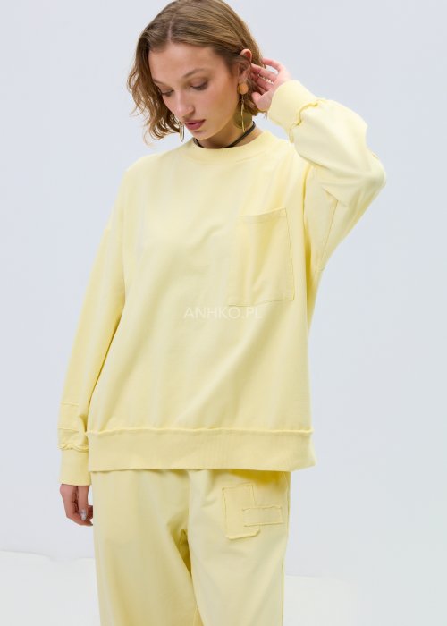 Jasnożółta bluza damska oversize z długim rękawem i kieszenią na piersi, o luźnym, komfortowym kroju.