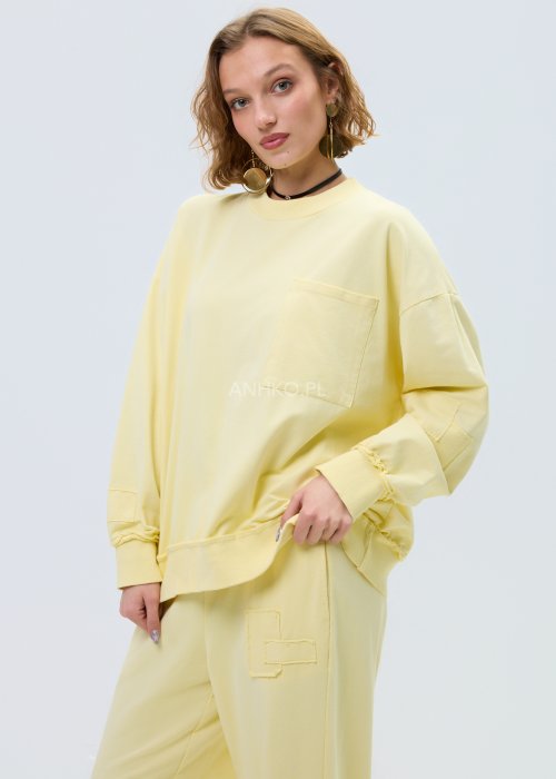 Jasnożółta bluza damska oversize z długim rękawem i kieszenią na piersi, o luźnym, komfortowym kroju.