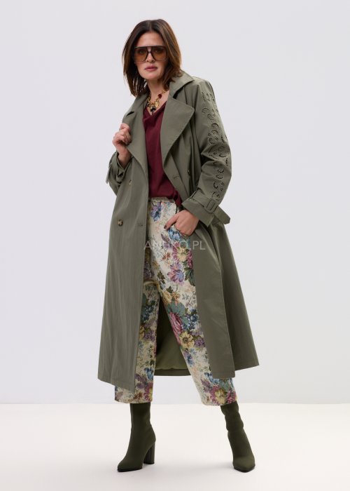 Wzorzyste spodnie damskie z motywem kwiatów, wykonane z tkaniny o strukturze, z kieszeniami po bokach.