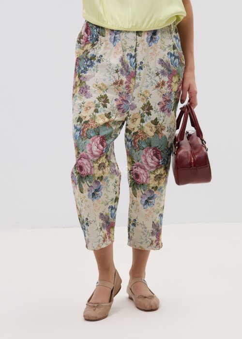 Wzorzyste spodnie damskie z motywem kwiatów, wykonane z tkaniny o strukturze, z kieszeniami po bokach.