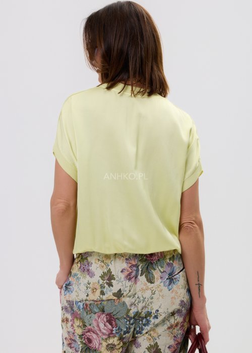 Luźna bluzka damska w odcieniu pastelowej żółci, z obniżoną linią ramion i minimalistycznym fasonem.