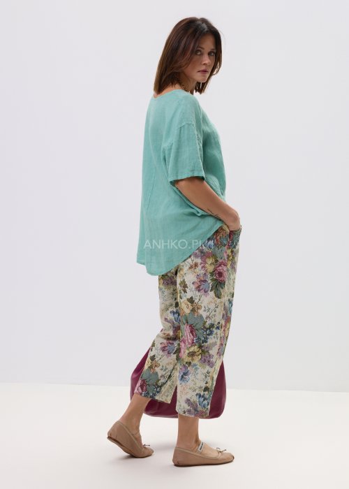 Luźna bluzka damska w kolorze mięty, z szerokim krojem i krótkim rękawem, zapewniająca swobodę noszenia.