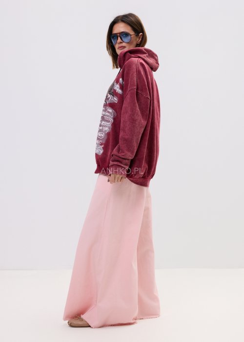 Eleganckie spodnie palazzo w kolorze pudrowego różu, z szerokimi nogawkami i surowym wykończeniem nogawek.