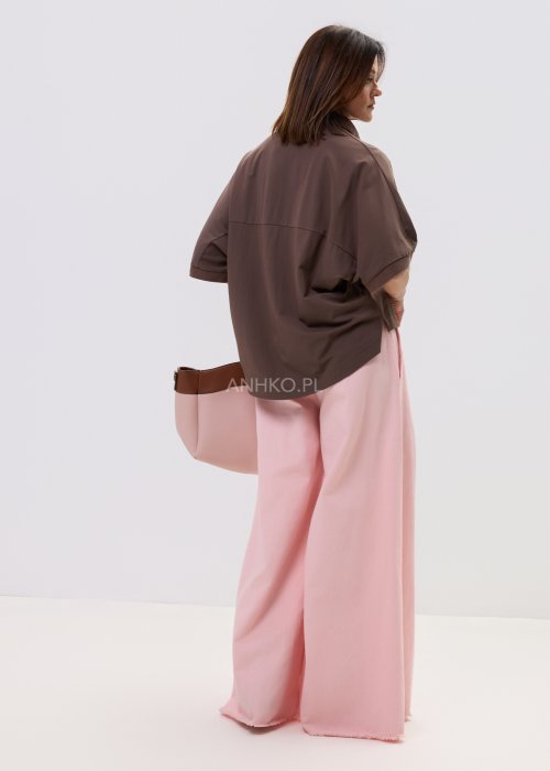 Eleganckie spodnie palazzo w kolorze pudrowego różu, z szerokimi nogawkami i surowym wykończeniem nogawek.