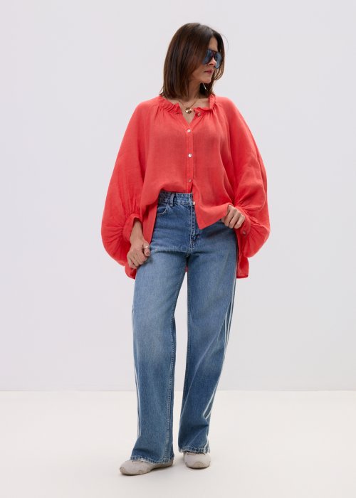 Koszula oversize w kolorze koralowym z lekkiej tkaniny, z szerokimi rękawami i subtelnym dekoltem.