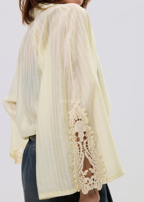 Koszula oversize w kolorze pastelowej żółci z subtelnym prążkiem i lekkiej, półtransparentnej tkaniny.