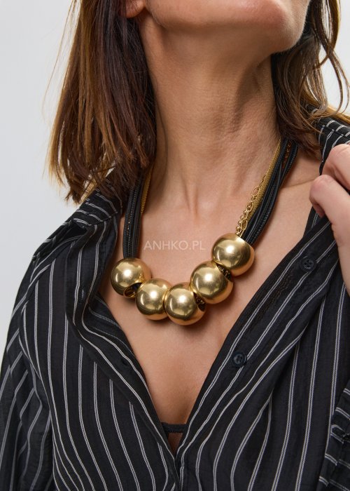Naszyjnik damski z dużymi złotymi kulami na czarnym sznurku, o wyrazistym i nowoczesnym designie.
