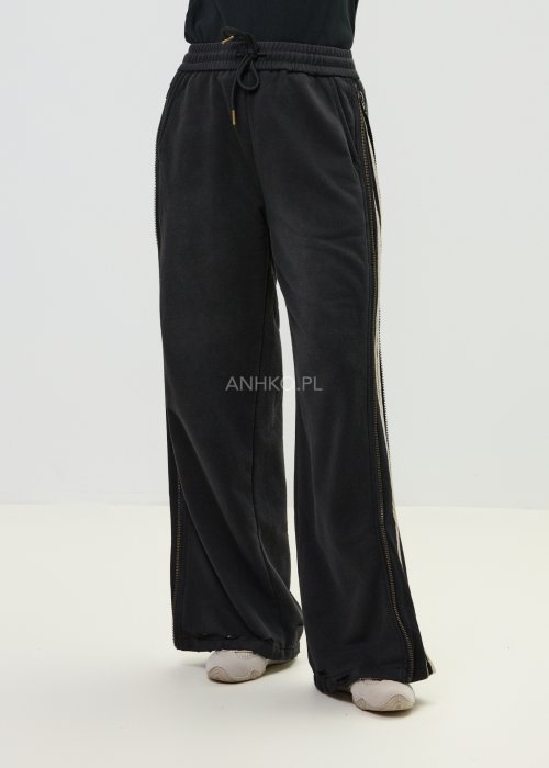 Damskie spodnie sportowe czarne z bocznymi paskami i suwakami