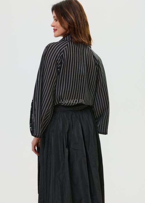 Czarna koszula damska w pionowe paski z ozdobnymi rękawami i koronkowym wykończeniem.