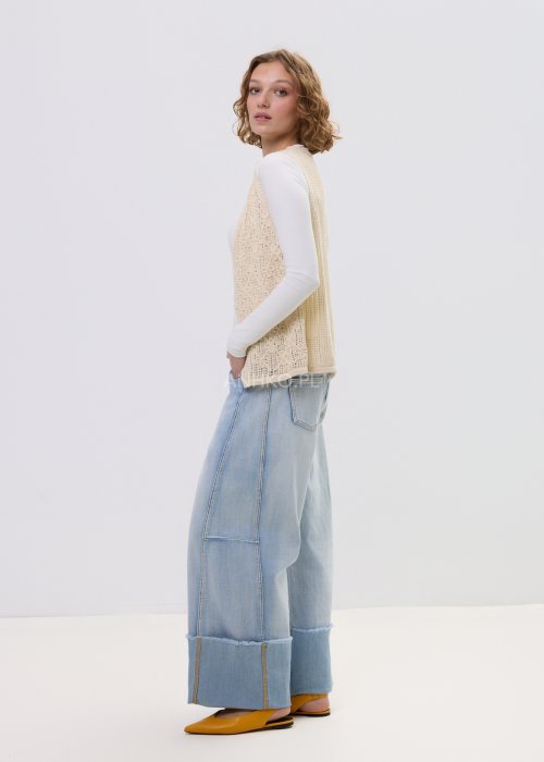 Jasne jeansy damskie z szeroką nogawką i surowym wykończeniem nogawek, z wysokim stanem i klasycznymi kieszeniami.