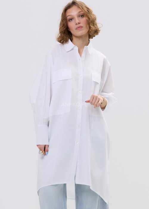 Biała koszula damska oversize o dłuższym fasonie z kołnierzem i kieszenią na piersi, z długim rękawem i zapięciem na guziki.