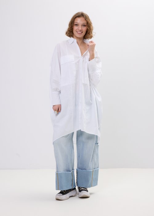 Biała koszula damska oversize o dłuższym fasonie z kołnierzem i kieszenią na piersi, z długim rękawem i zapięciem na guziki.