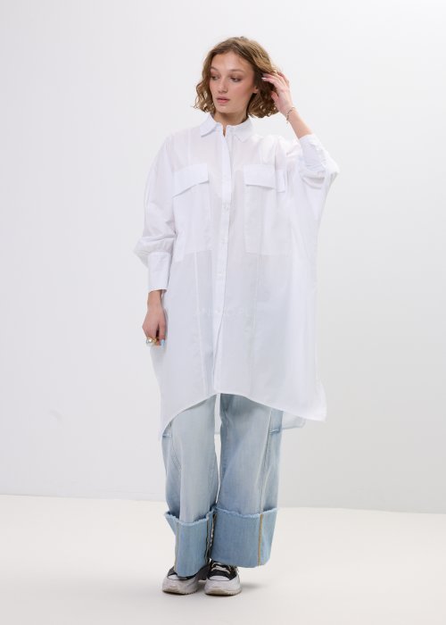 Biała koszula damska oversize o dłuższym fasonie z kołnierzem i kieszenią na piersi, z długim rękawem i zapięciem na guziki.