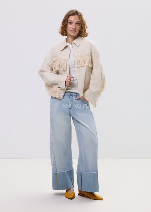 Beżowa kurtka damska z frędzlami i haftowanymi zdobieniami, zapinana na zamek, z kołnierzem i luźnym fasonem.