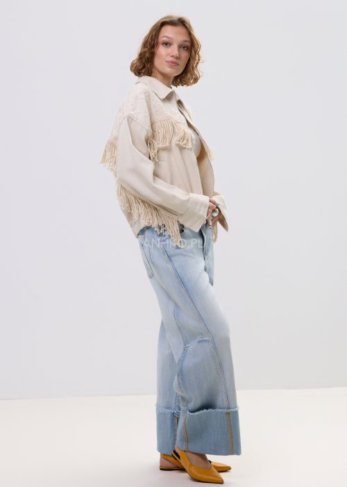 Beżowa kurtka damska z frędzlami i haftowanymi zdobieniami, zapinana na zamek, z kołnierzem i luźnym fasonem.