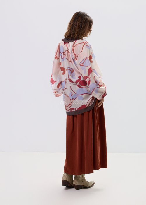 Spódnica sztruksowa maxi w kolorze ceglastym z wysokim stanem i paskiem do wiązania, o rozkloszowanym fasonie, stylizowana z lekką bluzką i botkami w stylu boho.