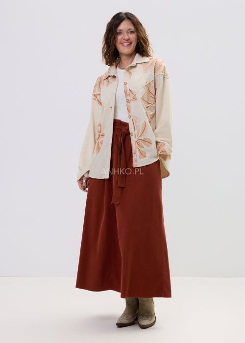 Koszula damska beżowa z haftowanym wzorem roślinnym w odcieniach karmelu, zapinana na guziki, z szerokim rękawem, stylizowana ze spódnicą midi.