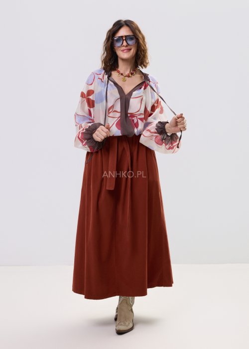 Bluzka damska z lekkiej, półtransparentnej tkaniny z abstrakcyjnym wzorem w odcieniach kremowym i czerwieni, z wiązaniem przy dekolcie i długimi rękawami.