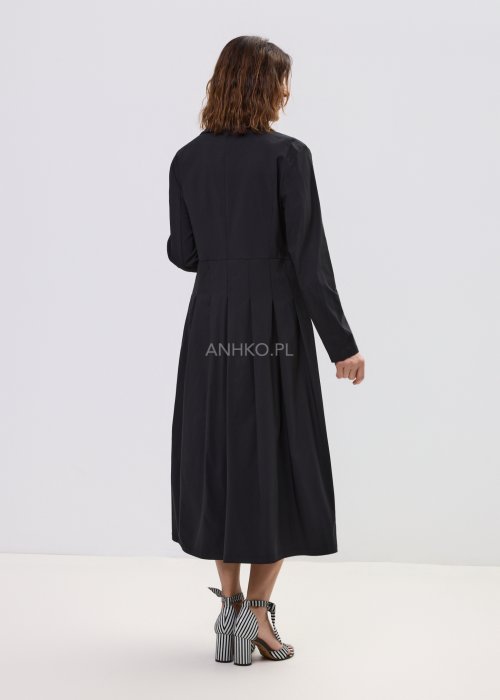 Czarna sukienka midi z kopertową górą i długim rękawem, o rozkloszowanym kroju, stylizowana z eleganckimi sandałami na obcasie.