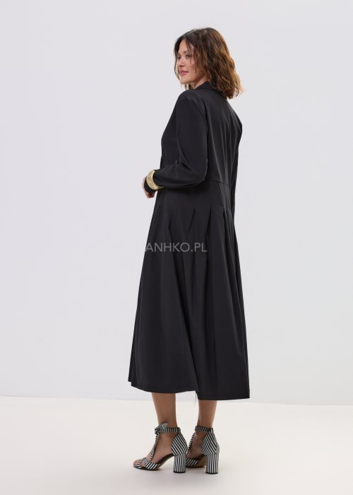 Czarna sukienka midi z kopertową górą i długim rękawem, o rozkloszowanym kroju, stylizowana z eleganckimi sandałami na obcasie.