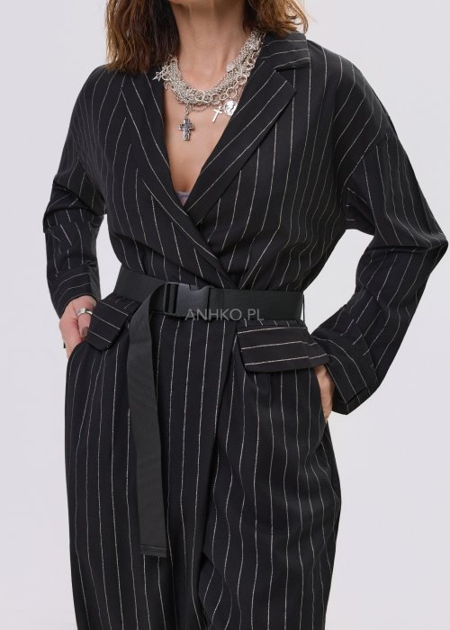 Czarny kombinezon damski w delikatny prążek z paskiem w talii, elegancki fason z dekoltem w serek, stylizacja miejska z botkami.