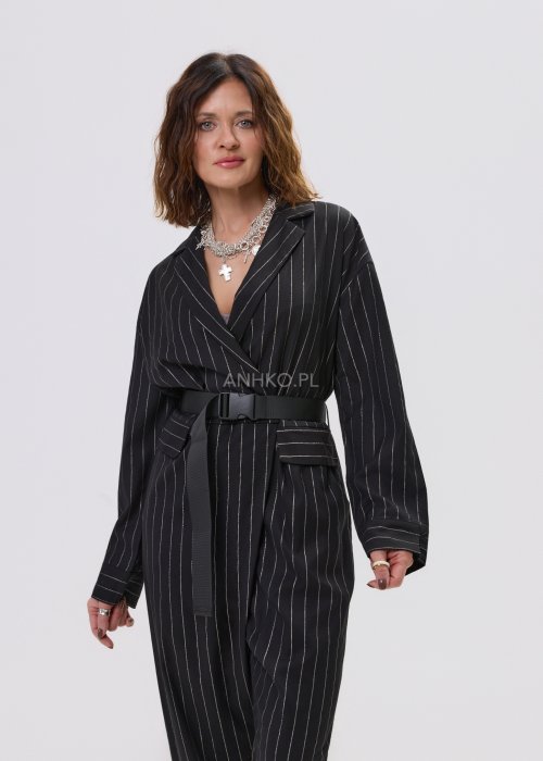 Czarny kombinezon damski w delikatny prążek z paskiem w talii, elegancki fason z dekoltem w serek, stylizacja miejska z botkami.